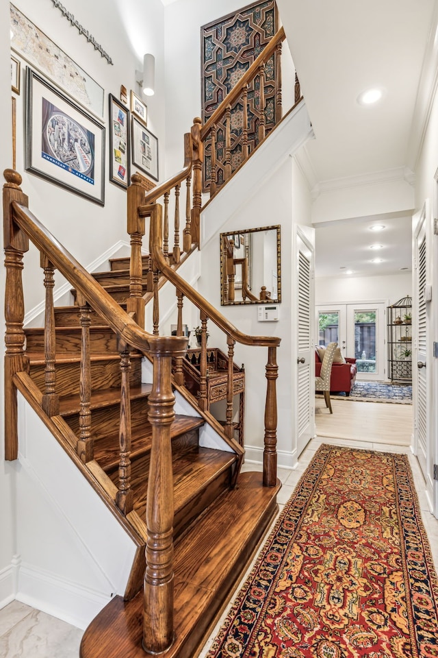 staircase featuring crown molding and french doors