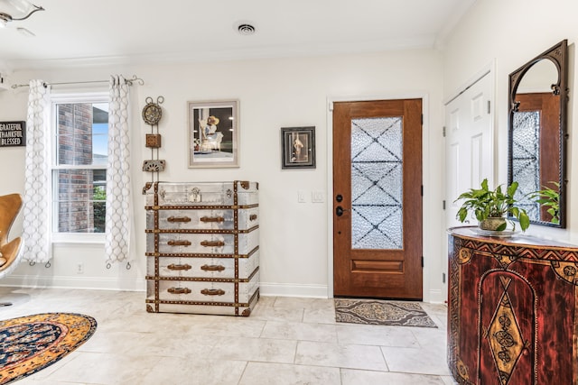 tiled foyer featuring crown molding