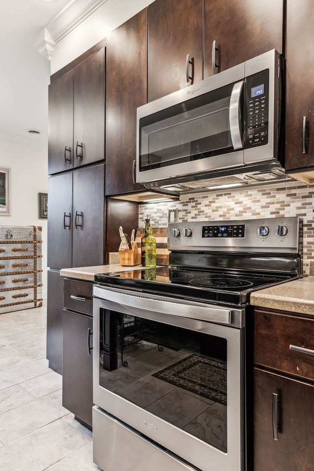 kitchen with dark brown cabinetry, backsplash, appliances with stainless steel finishes, and ornamental molding