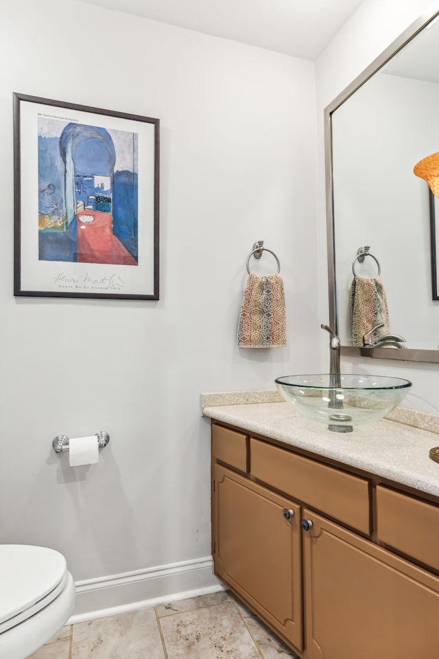 bathroom with toilet, vanity, and tile patterned floors