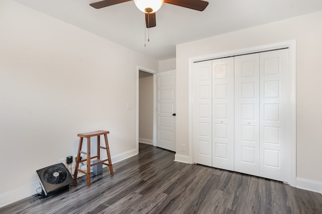 unfurnished bedroom featuring ceiling fan, a closet, and dark wood-type flooring