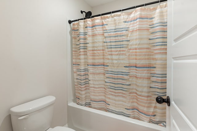 bathroom featuring shower / bath combo and toilet