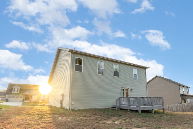 rear view of property with a yard and a wooden deck