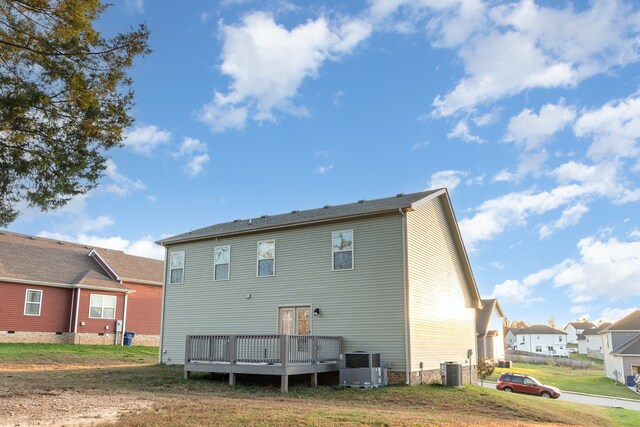 back of house with a yard, central air condition unit, and a wooden deck