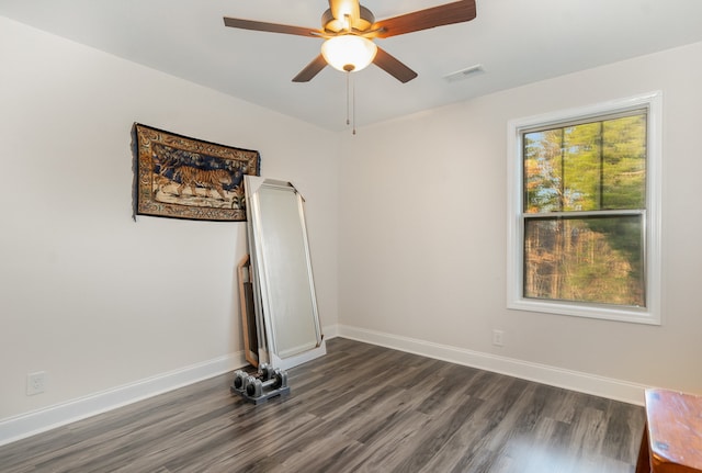 empty room with dark hardwood / wood-style floors and ceiling fan