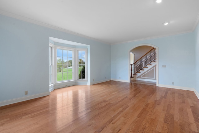 unfurnished living room with light wood-type flooring and ornamental molding