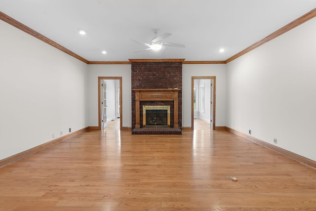 unfurnished living room with crown molding, light hardwood / wood-style flooring, and a brick fireplace