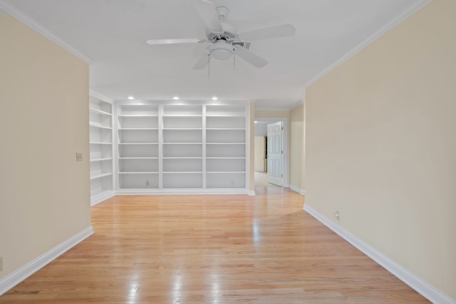 spare room with built in shelves, light hardwood / wood-style floors, ceiling fan, and ornamental molding