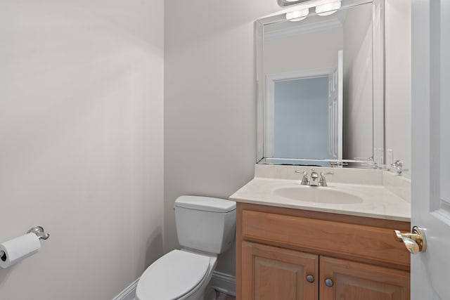 bathroom featuring vanity, toilet, and crown molding