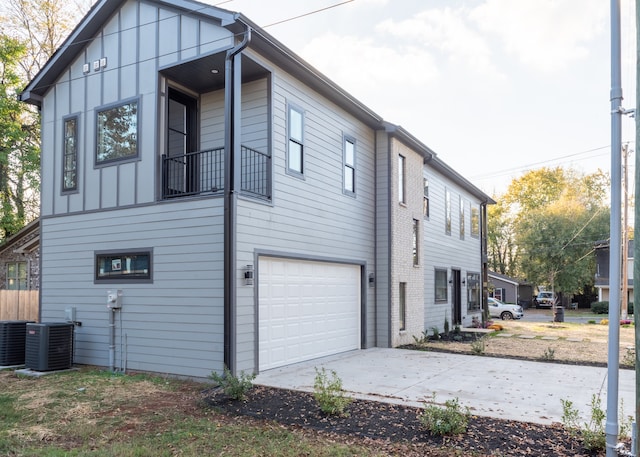 view of side of home featuring central AC and a garage