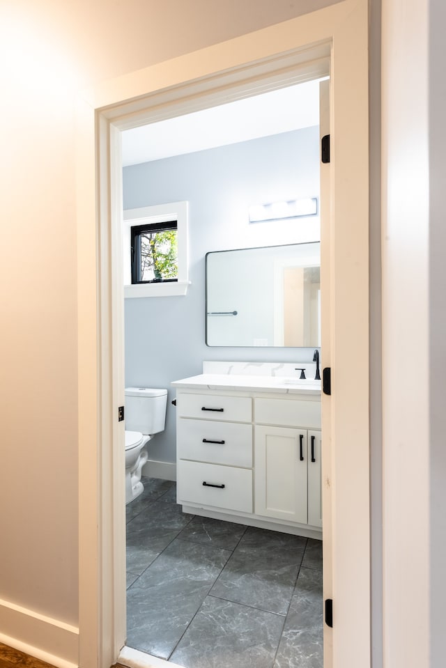 bathroom featuring tile patterned flooring, vanity, and toilet