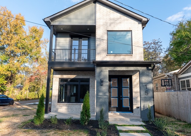 rear view of property with french doors and a balcony