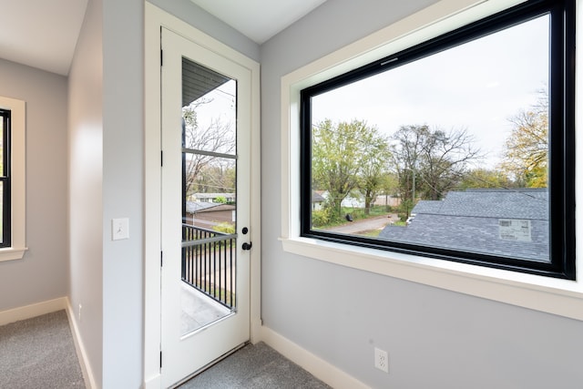 doorway to outside featuring carpet flooring and a healthy amount of sunlight