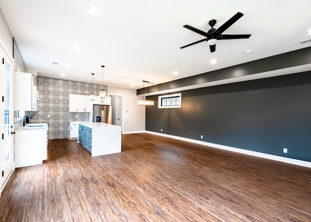 kitchen with pendant lighting, a center island, sink, stainless steel refrigerator with ice dispenser, and white cabinetry