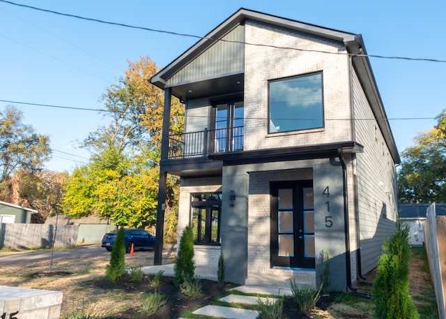 view of front of home featuring a balcony and french doors