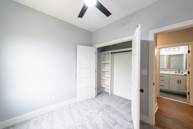 bedroom featuring connected bathroom, ceiling fan, sink, light hardwood / wood-style floors, and a closet