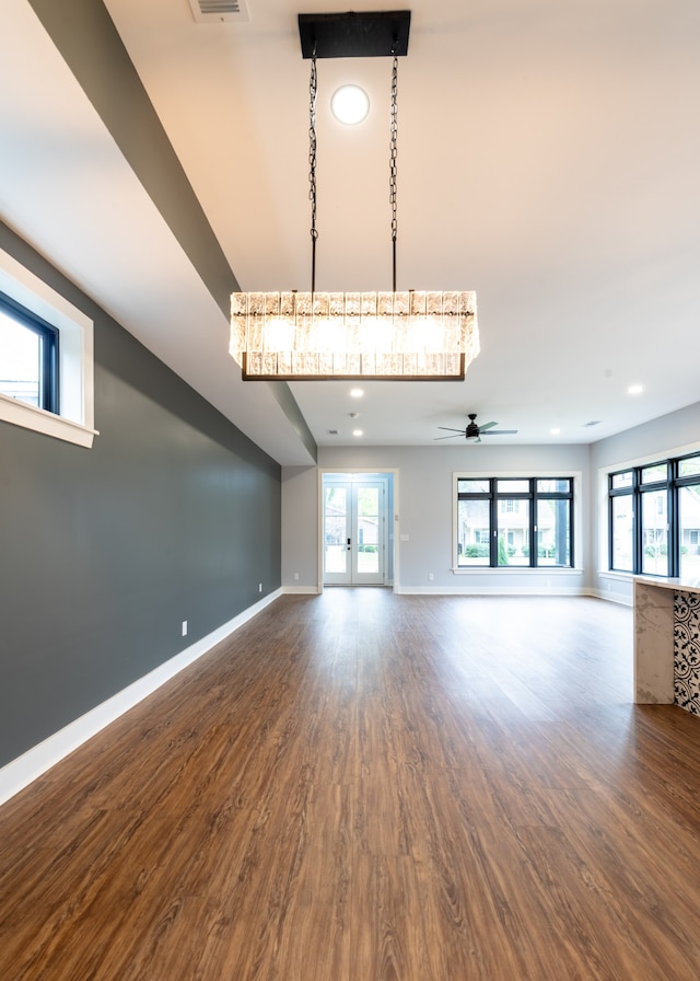 unfurnished living room featuring ceiling fan, french doors, and wood-type flooring