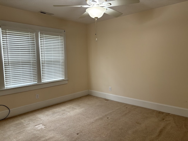 spare room with light colored carpet and ceiling fan