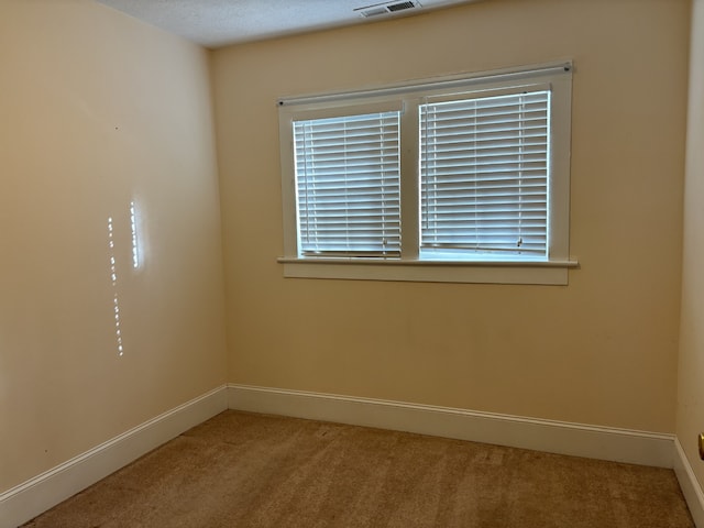 carpeted empty room with a textured ceiling