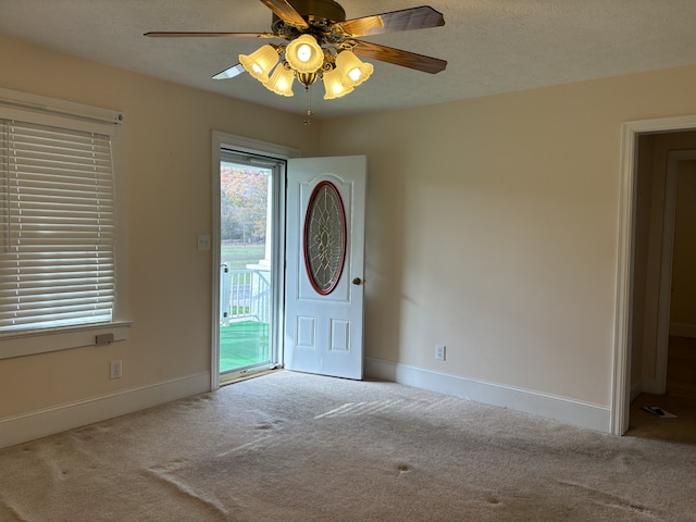 carpeted foyer entrance featuring a textured ceiling and ceiling fan