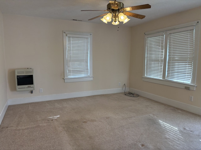 spare room featuring ceiling fan, light colored carpet, and heating unit