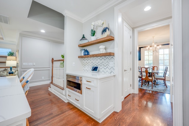 kitchen featuring white cabinets, dark hardwood / wood-style flooring, a chandelier, and tasteful backsplash