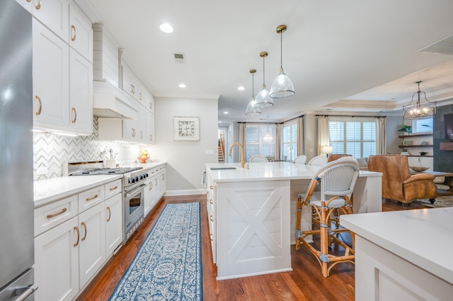 kitchen featuring appliances with stainless steel finishes, decorative light fixtures, white cabinetry, and dark wood-type flooring