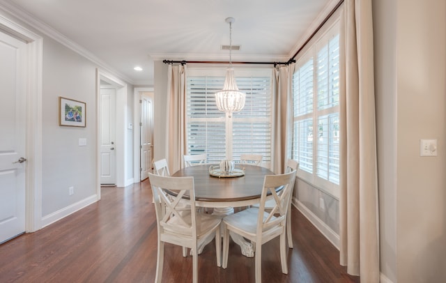 dining area featuring crown molding, dark wood-type flooring, and an inviting chandelier