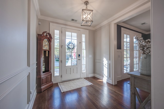 foyer entrance with dark hardwood / wood-style flooring, a chandelier, and ornamental molding