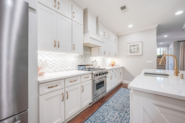 kitchen featuring light stone countertops, stainless steel appliances, dark wood-type flooring, sink, and white cabinetry