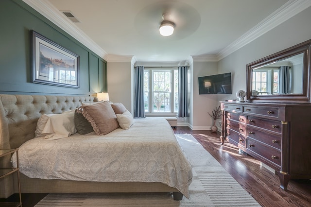 bedroom with multiple windows, ceiling fan, dark hardwood / wood-style floors, and ornamental molding