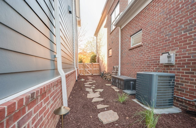 view of side of home with cooling unit and a wall unit AC