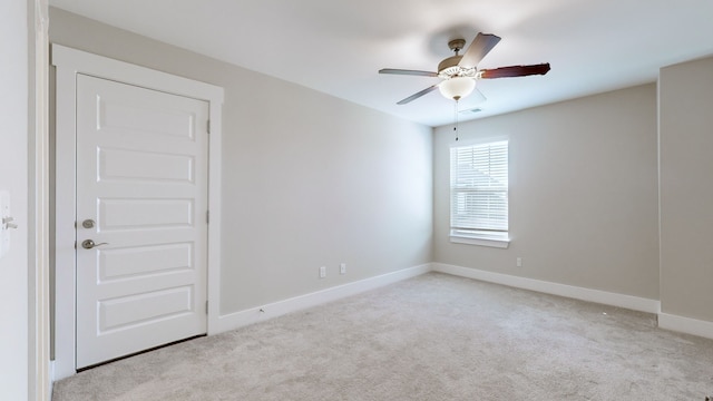 spare room with light colored carpet and ceiling fan