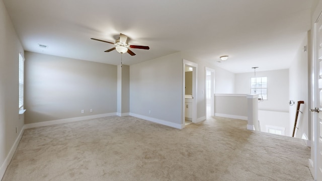 spare room with ceiling fan and light colored carpet