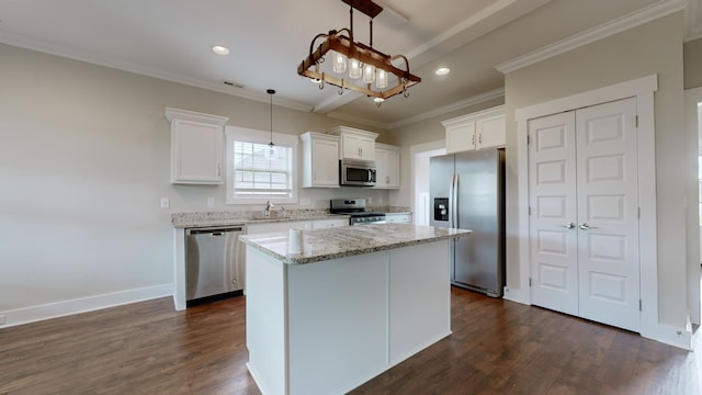 kitchen featuring appliances with stainless steel finishes, pendant lighting, a center island, dark hardwood / wood-style floors, and white cabinetry