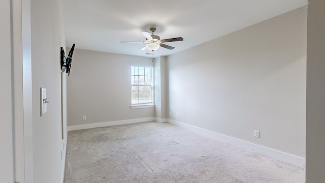 carpeted spare room featuring ceiling fan