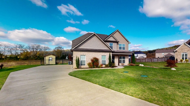 craftsman inspired home featuring a storage shed and a front lawn