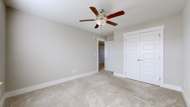 unfurnished bedroom featuring ceiling fan, light carpet, and a closet