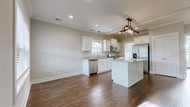 kitchen featuring hanging light fixtures, white cabinets, dark hardwood / wood-style flooring, a kitchen island, and appliances with stainless steel finishes