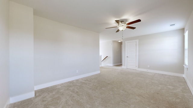 carpeted spare room featuring ceiling fan