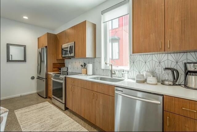 kitchen featuring decorative backsplash, sink, and appliances with stainless steel finishes