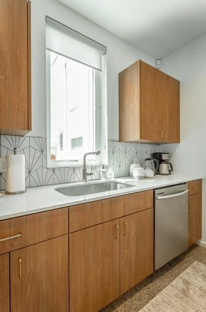 kitchen featuring backsplash, dishwasher, and sink