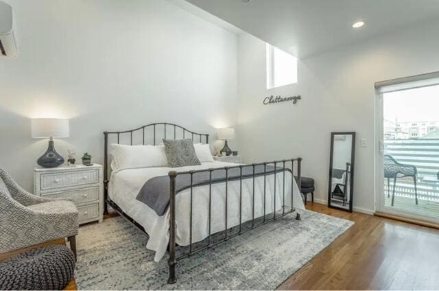 bedroom with access to exterior, light hardwood / wood-style flooring, and multiple windows