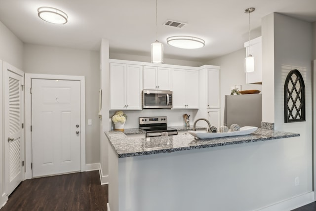 kitchen featuring dark hardwood / wood-style flooring, kitchen peninsula, decorative light fixtures, white cabinets, and appliances with stainless steel finishes