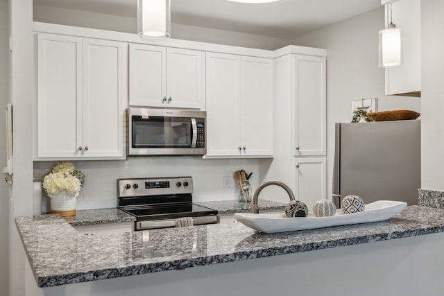 kitchen featuring white cabinets, decorative light fixtures, stainless steel appliances, and tasteful backsplash