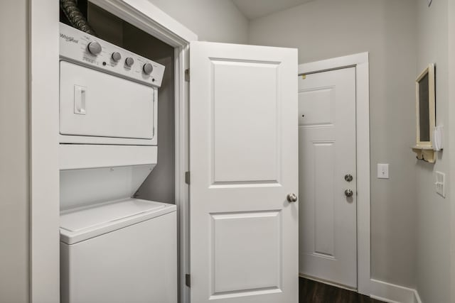 laundry room with stacked washer / dryer and dark hardwood / wood-style floors