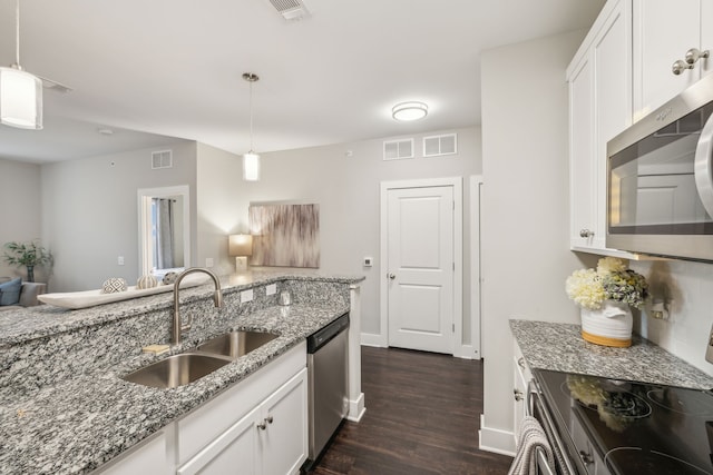 kitchen with light stone countertops, sink, dark wood-type flooring, stainless steel appliances, and white cabinets