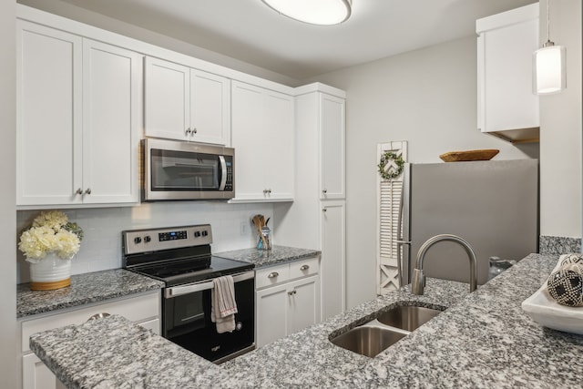 kitchen featuring sink, tasteful backsplash, decorative light fixtures, white cabinets, and appliances with stainless steel finishes