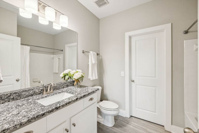 full bathroom featuring shower / bath combination with curtain, vanity, wood-type flooring, and toilet