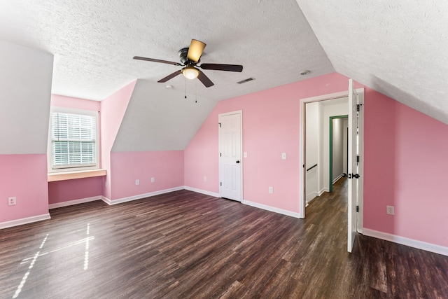 bonus room with a textured ceiling, dark hardwood / wood-style flooring, ceiling fan, and lofted ceiling